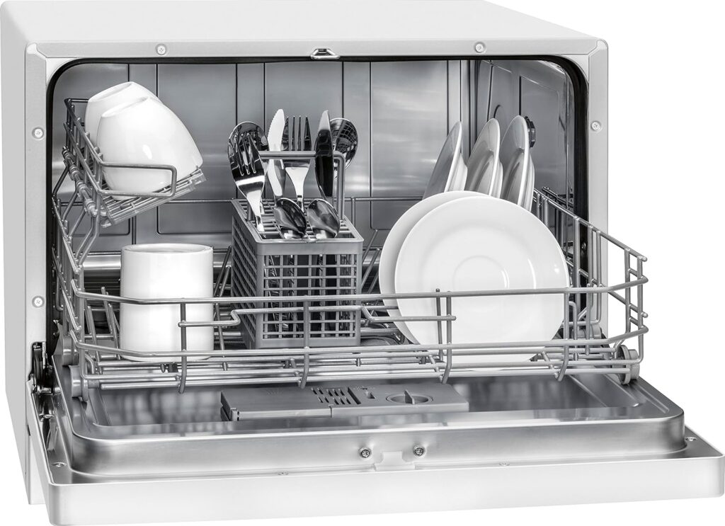 Bomann TSG 707 lave-vaisselle compact ouvert avec vaisselle propre, montrant des assiettes, des tasses et des couverts rangés de manière ordonnée. Vue intérieure détaillée pour illustration produit.